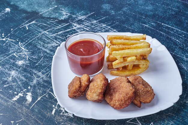 Cotolette con patate fritte e salsa.