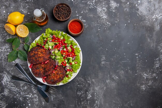 Cotolette di carne vista dall'alto con insalata e pane