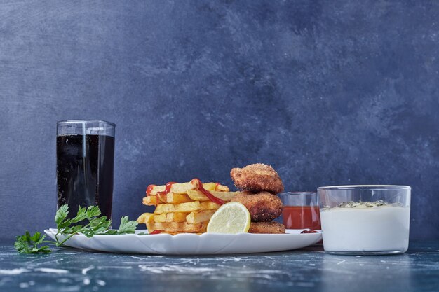 Cotolette di pollo fritte con patate e bevanda.