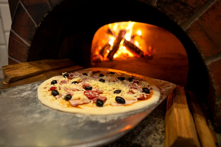Foto gratuito cottura deliziosa pizza con forno a legna