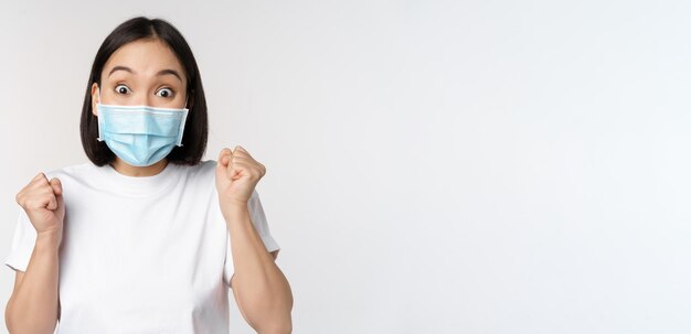 Covid assistenza sanitaria e concetto medico donna asiatica entusiasta in maschera medica che balla e celebrità