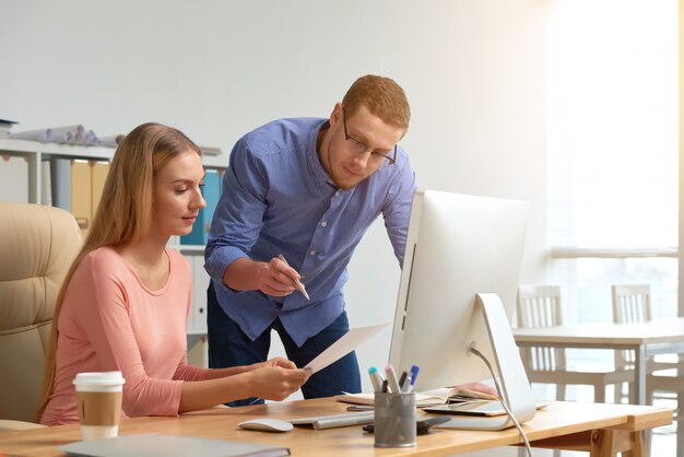 Coworking della donna e dell'uomo sul documento di affari che genera le idee