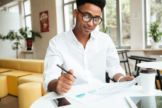 Coworking di seduta del giovane uomo africano felice