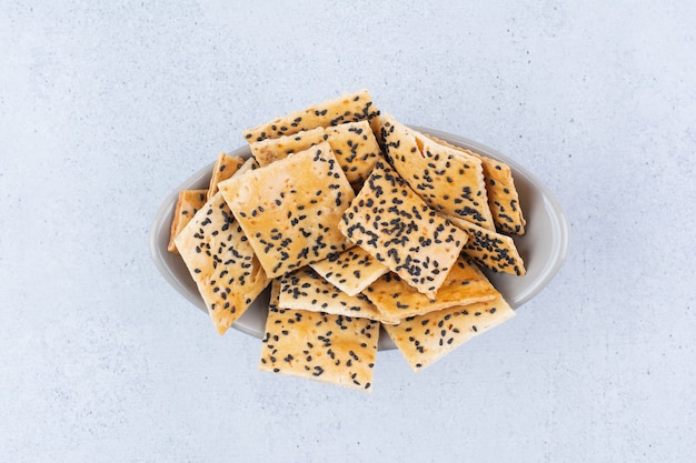 Cracker con semi di sesamo nero nella ciotola.