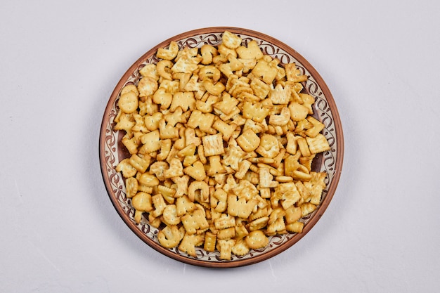 Cracker deliziosi di alfabeto su un piatto di ceramica.