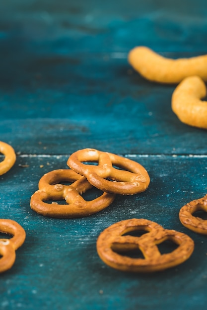 Cracker della ciambellina salata e spuntini sulla tavola blu