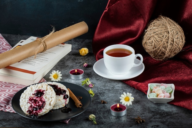 Cracker dietetici con marmellata rossa e cannella e una tazza di tè