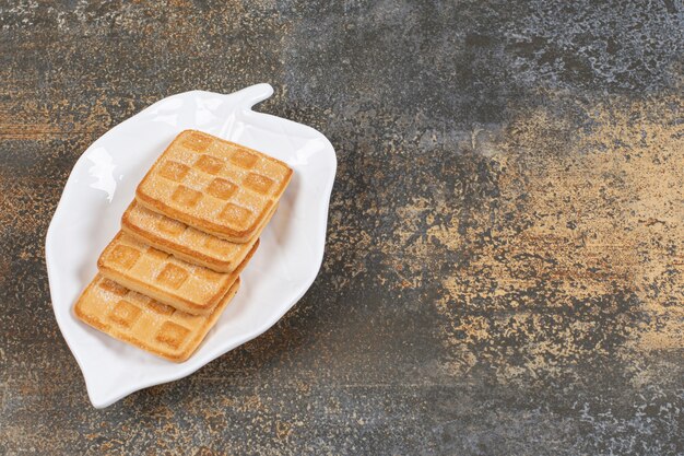 Cracker dolci quadrati su piatto a forma di foglia.