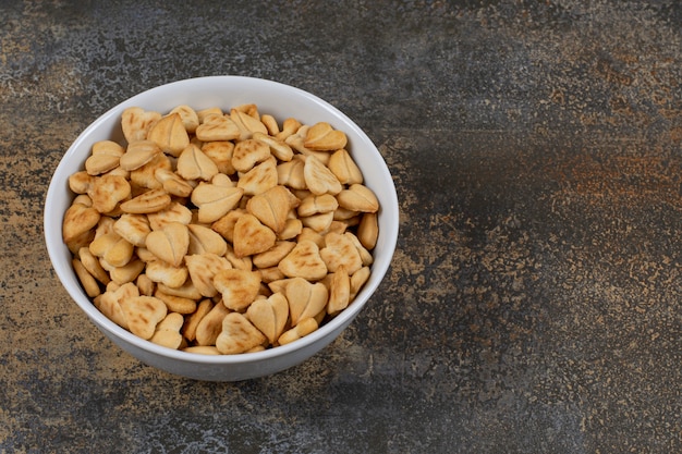 Cracker salati a forma di cuore in ciotola bianca.