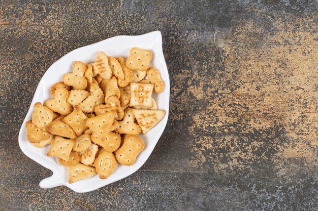 Cracker salati di varie forme su piatto a forma di foglia.