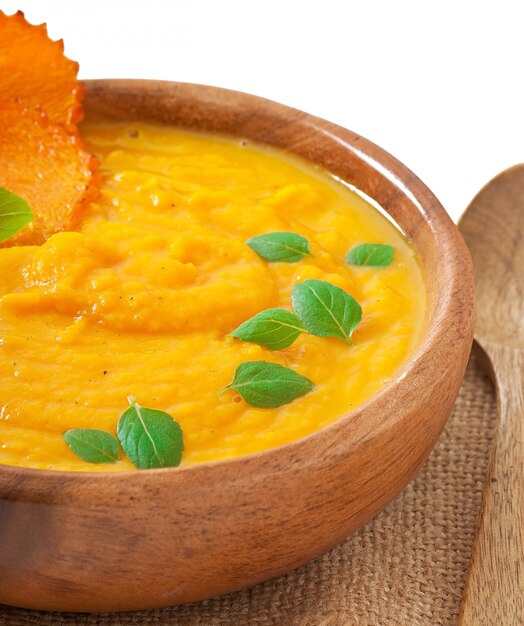 Crema di zuppa di zucca in una ciotola di legno