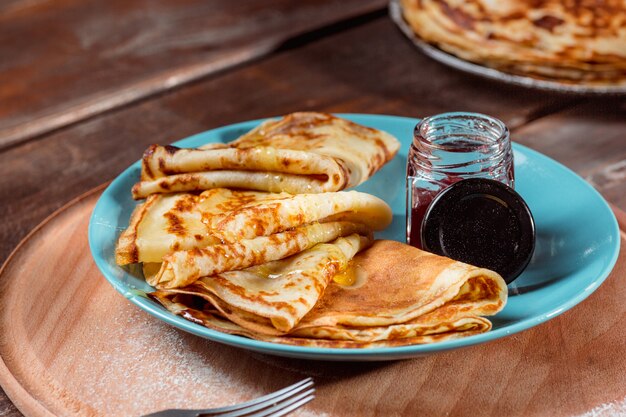 Crepes francesi fatte in casa fresche fatte con uova, latte e farina, riempite di marmellata su un piatto d'annata