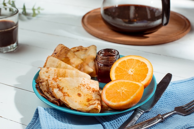 Crepes francesi fatte in casa fresche fatte con uova, latte e farina, riempite di marmellata su un piatto d'annata