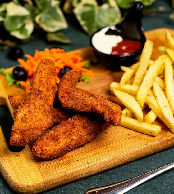 Crocchette di pollo in stile kfc con patatine fritte, maionese, ketchup e insalata di verdure