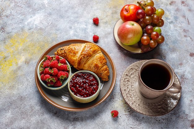 Croissant appena sfornati con marmellata di lamponi e frutti di lampone.