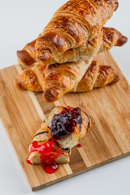 Croissant con inceppamento su bianco e tagliere, vista dell'angolo alto.