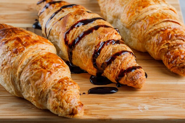 Croissant con salsa di cioccolato close-up su un tavolo di legno