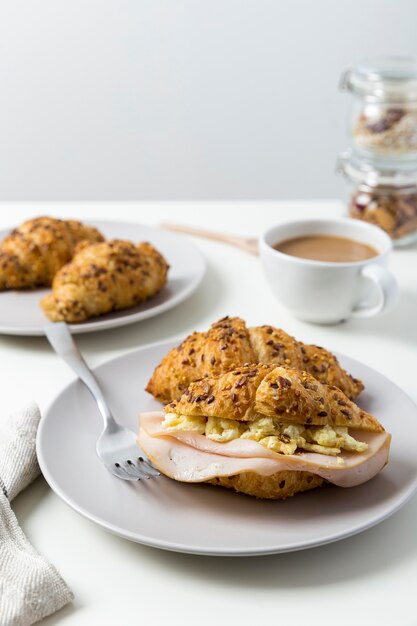 Croissant del prosciutto e dell'uovo del primo piano su una zolla