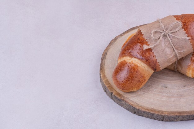 Croissant isolati su un piatto di legno sulla superficie grigia