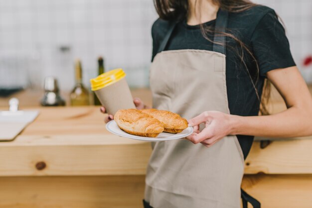 Crop barista con bevande e pasticceria