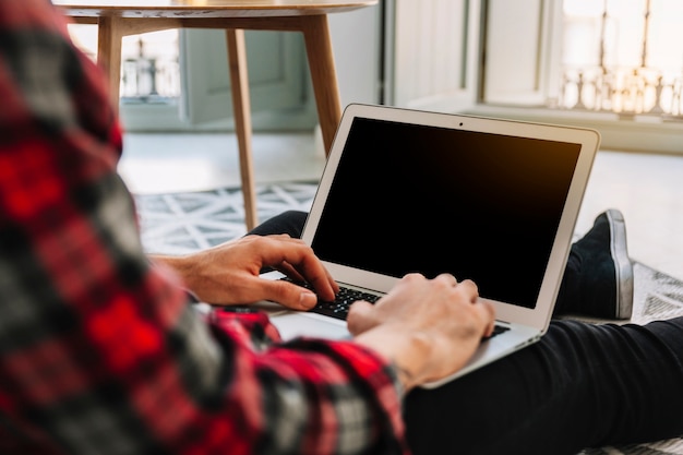 Crop man browsing laptop