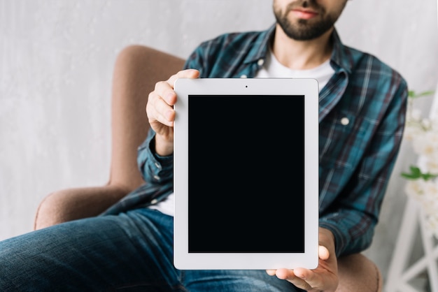 Crop man showing tablet