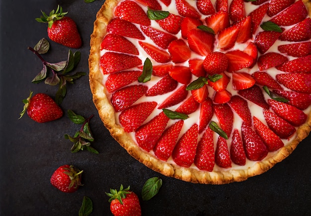 Crostata con fragole e panna montata decorata con foglie di menta. Vista dall'alto