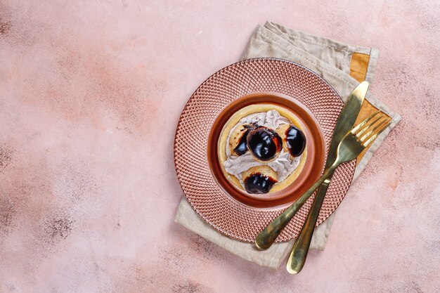 Crostata con profiteroles sopra con panna montata.