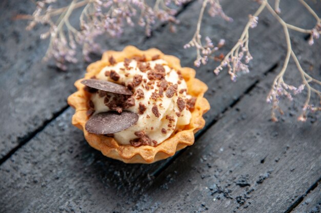 Crostata vista dal basso con ramo di fiori secchi al cioccolato sulla tavola di legno scuro