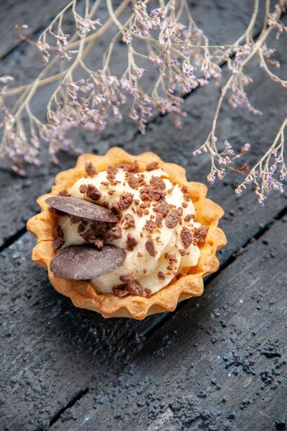 Crostata vista dall'alto con ramo di fiori secchi al cioccolato su superficie di legno scuro