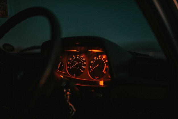 Cruscotto auto illuminato in rosso con un volante di notte