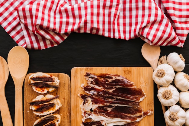 Cucchiai e tovaglioli vicino all&#39;aglio e al cibo