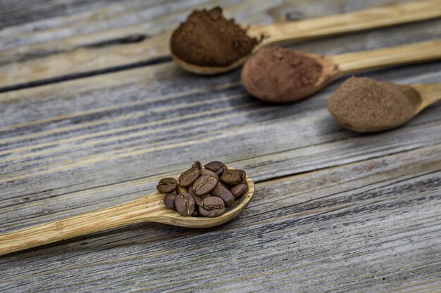 Cucchiaini di legno con chicchi di caffè e polvere di caffè