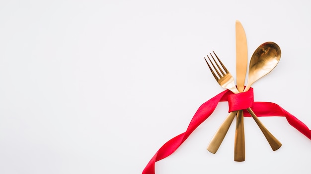 Cucchiaio, coltello e forchetta con nastro rosso