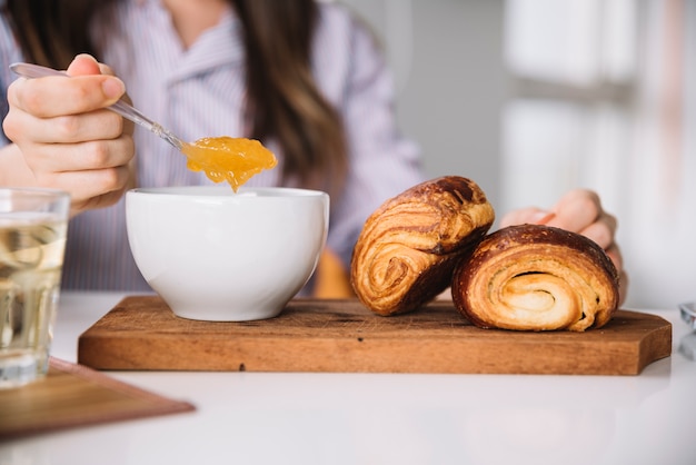 Cucchiaio della tenuta della donna con inceppamento vicino ai panini