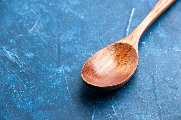Cucchiaio di legno vista dal basso sul posto della copia di superficie blu