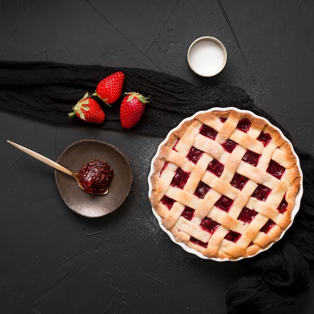 Cucchiaio pieno di marmellata di fragole e torta vista dall'alto