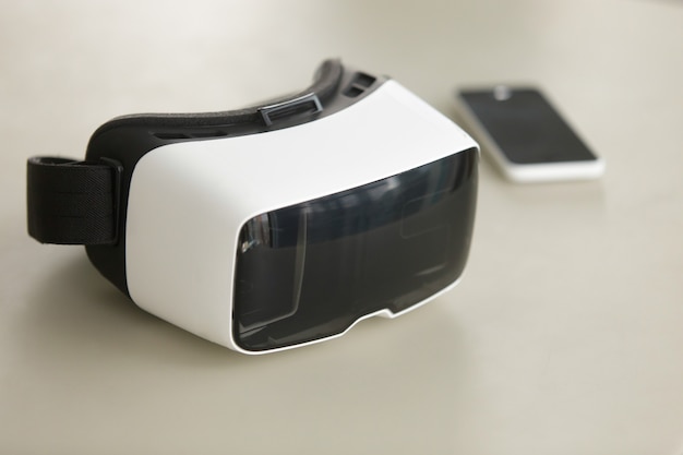 Cuffie VR e smartphone su scrivania, tecnologia mobile per realtà virtuale