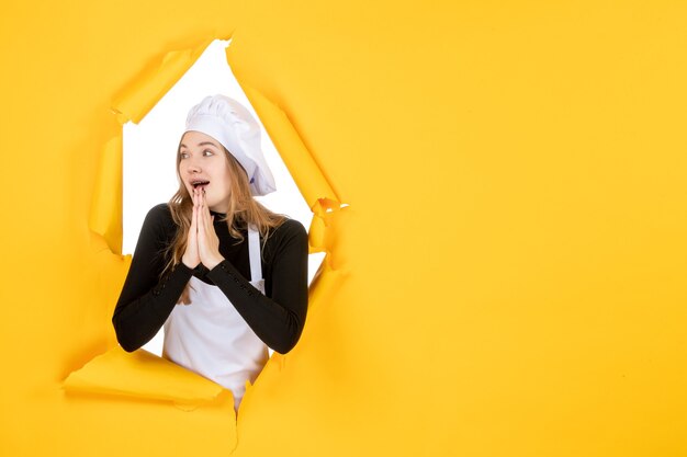 Cuoca di vista frontale che prega su carta di colore giallo sole lavoro foto cucina emozione cibo