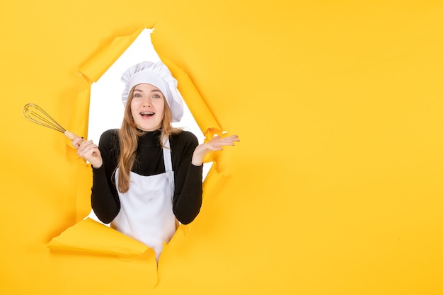 Cuoca vista frontale in berretto da cuoco bianco su lavoro giallo emozione cucina colore cucina foto cucina