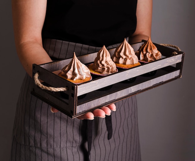 Cuocere il vassoio con cupcakes e glassa
