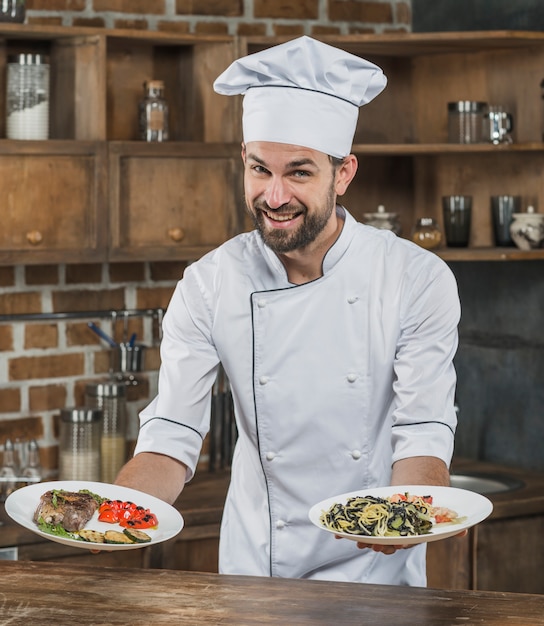 Cuoco maschio che sta in cucina che presenta piatto delizioso