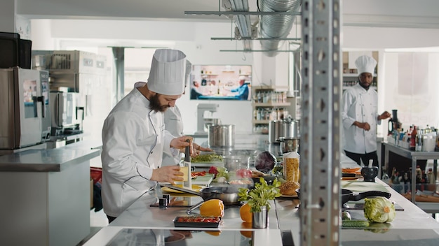 Cuoco professionista che usa la grattugia per preparare il formaggio grattugiato per la ricetta del cibo italiano nella cucina del ristorante. Chef maschio in ingrediente parmigiano grattugiato uniforme per preparare deliziosi pasti gourmet culinari.