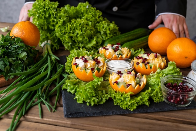 Cuoco unico che presenta piatto con insalata