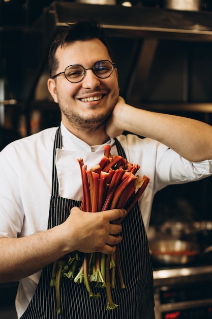 Cuoco unico che tiene il rabarbaro in cucina