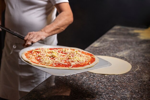 Cuoco unico di vista frontale che prepara pizza