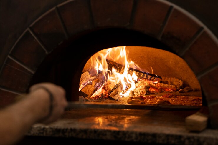 Foto gratuito cuoco unico di vista laterale che cucina pizza deliziosa