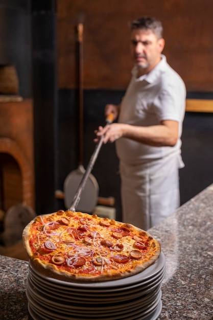 Cuoco unico di vista laterale che prepara pizza