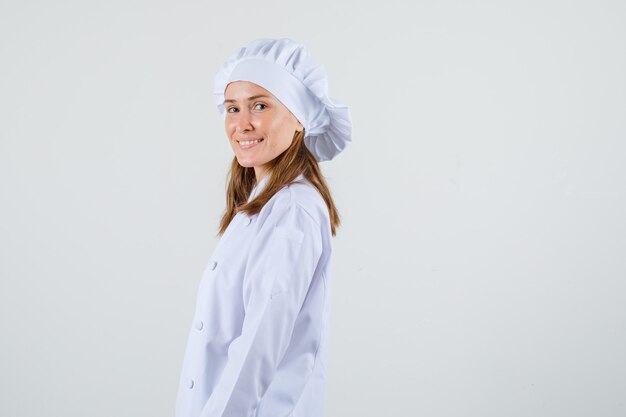 Cuoco unico femminile che guarda l'obbiettivo in uniforme bianca e sembra ottimista.