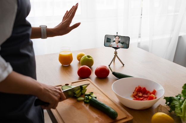 Cuoco unico femminile che ha una videochiamata mentre cucina